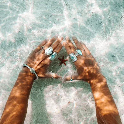 Embella jewellery worn beside a starfish in ocean water