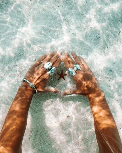 Embella jewellery worn beside a starfish in ocean water